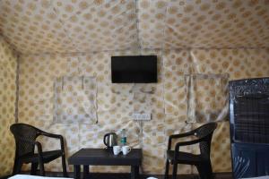 a room with two chairs and a table and a television at Araku Mountview Camping Resort in Araku
