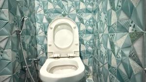 a bathroom with a toilet with blue tiled walls at D S valley in Rishīkesh