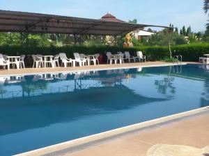 a swimming pool with white chairs and a table at Lomdao Resort in Ban Khao San