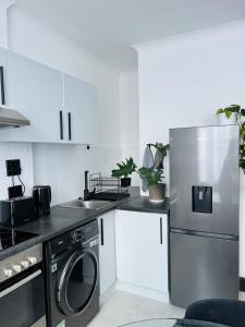una cucina con frigorifero e lavastoviglie di Black Pearl Oasis a Città del Capo