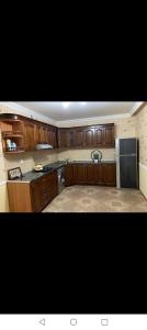 a kitchen with wooden cabinets and a stainless steel refrigerator at Gabala villa in Gabala