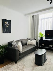 un soggiorno con un divano e un tavolo di Black Pearl Oasis a Città del Capo