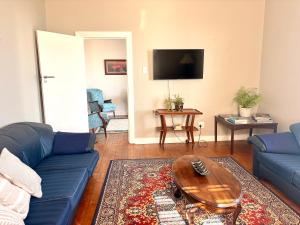 a living room with a blue couch and a table at Sunrise & Sunset Haven in Mossel Bay