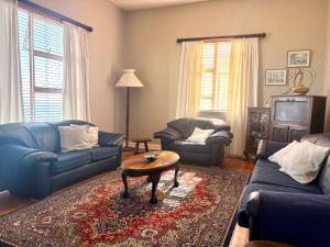 ein Wohnzimmer mit blauen Sofas und einem Couchtisch in der Unterkunft Sunrise & Sunset Haven in Mossel Bay