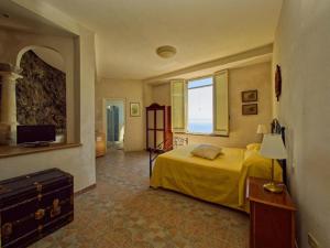 a bedroom with a yellow bed and a television at Villa Scarpariello Relais in Ravello +57 photos