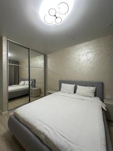 ein Schlafzimmer mit einem großen weißen Bett und einem Spiegel in der Unterkunft ЖК Варшавський - Balance Home in Ternopil