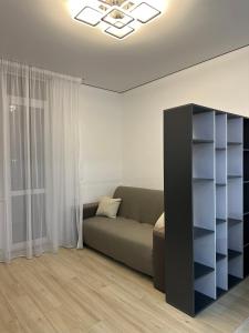 ein Wohnzimmer mit einer Couch und einem Bücherregal in der Unterkunft ЖК Варшавський - Balance Home in Ternopil
