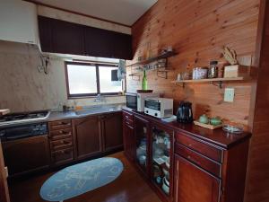 a small kitchen with wooden cabinets and a counter top at 戸隠の自然に佇む 小さな一棟貸しコテージ Private Tiny Cottage in the Nature of Togakushi Breath in Earth in Nagano