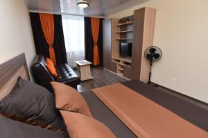 エカテリンブルクにあるApartments Аlexandria on Zavodskaya 75のベッドルーム(ベッド1台、椅子、テレビ付)
