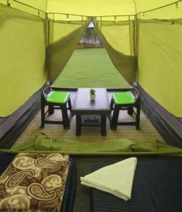a tent with a table and two chairs in it at Araku Mountview Camping Resort in Araku