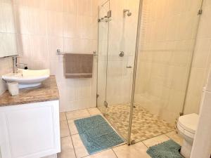 ein Badezimmer mit Dusche, Waschbecken und Toilette in der Unterkunft Sunrise & Sunset Haven in Mossel Bay + 20 Fotos