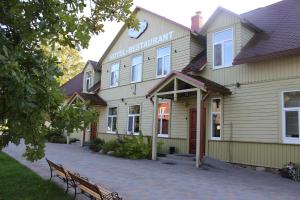 a building with a bench in front of it at Pilsberģu krogs in Jūrkalne