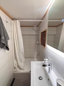 a white bathroom with a sink and a shower at L'appart du Yeti, cocon rénové avec goût, multipass été, ménage et linges compris in Les Gets +31 photos