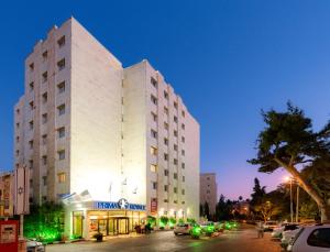 a large white building on a city street at night at Prima Royale Hotel in Jerusalem
