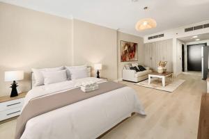 a large white bedroom with a large bed and a couch at Stylish Furnsihed Apartments Opposite Five Hotel In JVC in Dubai +39 photos