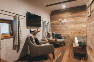 a living room with two chairs and a tv at Domačija Majer'ca in Bohinj +22 photos