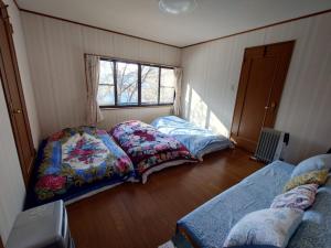 Ένα ή περισσότερα κρεβάτια σε δωμάτιο στο 戸隠の自然に佇む 小さな一棟貸しコテージ Private Tiny Cottage in the Nature of Togakushi Breath in Earth