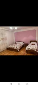 two beds in a room with purple walls and wooden floors at Gabala villa in Gabala +45 photos