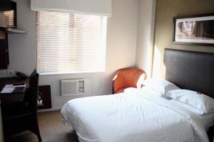 una camera con un letto bianco e una finestra di Illovo Hotel a Johannesburg