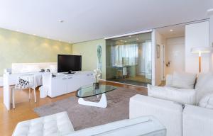 a living room with a white couch and a tv at Hotel-Bodega Finca de Los Arandinos in Entrena