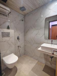 a bathroom with a white toilet and a sink at hotel Sunrise Residency in Mumbai +13 photos