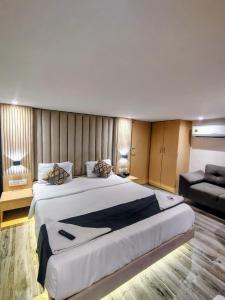 a large bedroom with a large bed and a couch at hotel Sunrise Residency in Mumbai