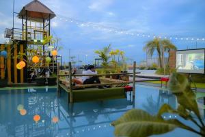two people sitting in a pool at a resort at Grand Qin Hotel Syariah in Martapura