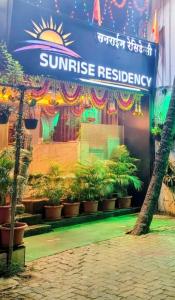 a sun rise restaurant with plants in front of it at hotel Sunrise Residency in Mumbai