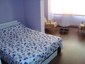 um quarto com uma cama com um edredão azul e branco em Apartamentul Republicii em Alba Iulia