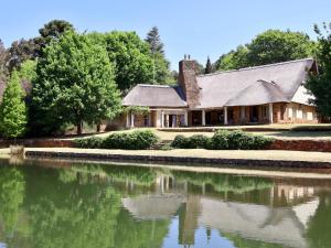 een huis met een vijver ervoor bij Winnaarspoort Lodge in Hydro