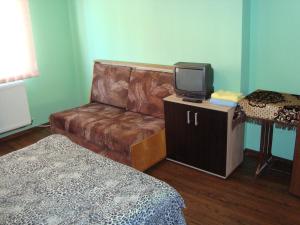 um quarto com um sofá e uma televisão num armário em Apartamentul Republicii em Alba Iulia