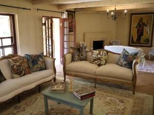 een woonkamer met twee banken en een tafel bij Winnaarspoort Lodge in Hydro