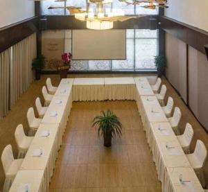 a large room with a long table and white chairs at Chengdu Nine Point Art Hotel in Chengdu