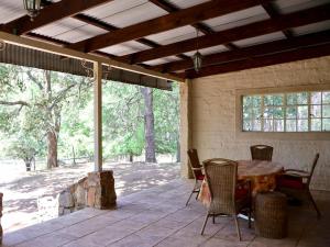 een patio met een tafel en stoelen en een groot raam bij Winnaarspoort Lodge in Hydro