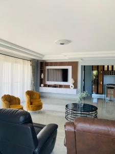 a living room with a couch and a table and chairs at Khulanathi Guesthouse in Engcobo