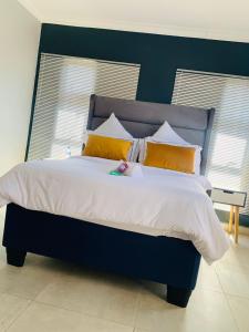 a bedroom with a large bed with yellow pillows at Khulanathi Guesthouse in Engcobo