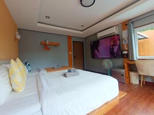 ein Schlafzimmer mit einem großen weißen Bett und einem Flachbildfernseher in der Unterkunft Anita dream house in Khao Sok