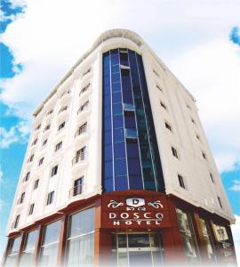 a large white building with a sign on it at Hotel Dosco in Van