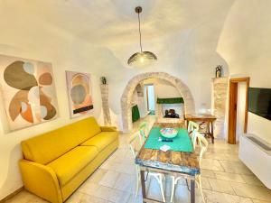 a living room with a yellow couch and a table at Trulli Phoenix Alberobello in Alberobello
