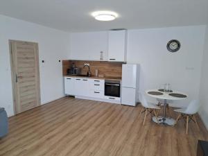 una cucina con un tavolo e un frigorifero bianco di Apartmány Karpatia s historickým výkladom a Svidník