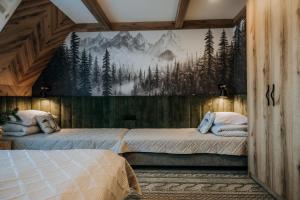 two beds in a room with a mural on the wall at Pokoje Gościnne u Moniki Zakopane in Zakopane