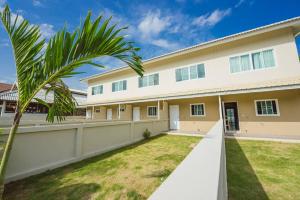 ein Haus mit einer Palme davor in der Unterkunft Donkaew minimalist townhouse in Ban Mae Sa Luang