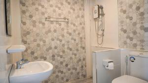 ein Badezimmer mit Waschbecken und Toilette in der Unterkunft Donkaew minimalist townhouse in Ban Mae Sa Luang