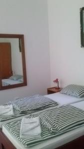 Una cama con espejo y dos toallas. en Guesthouse Daniel, en Oradea