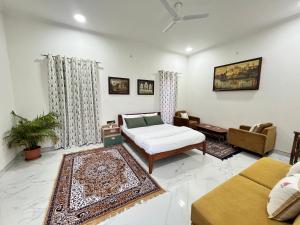 a living room with a bed and a couch at Flora A suite in Jaipur
