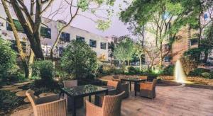 une cour avec des tables, des chaises et une fontaine dans l'établissement Atour Hotel Weihai Shidao, à Dongshan