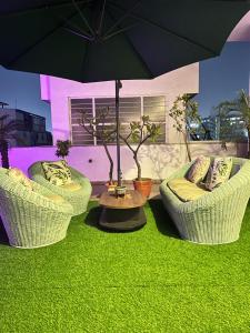 twee stoelen en een tafel met een parasol bij Flora A rooftop with serenity and peace in Jaipur