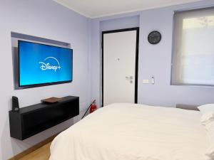 een slaapkamer met een bed en een flatscreen-tv bij Mario's Holiday House in Barcuzzi +4 foto's