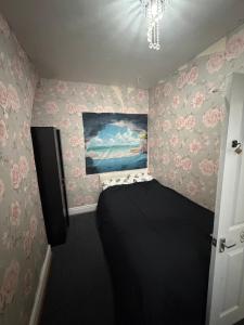 een kleine slaapkamer met roze bloemen aan de muren bij Homey room in Liverpool
