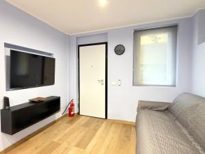 een woonkamer met een bank, een tv en een raam bij Mario's Holiday House in Barcuzzi